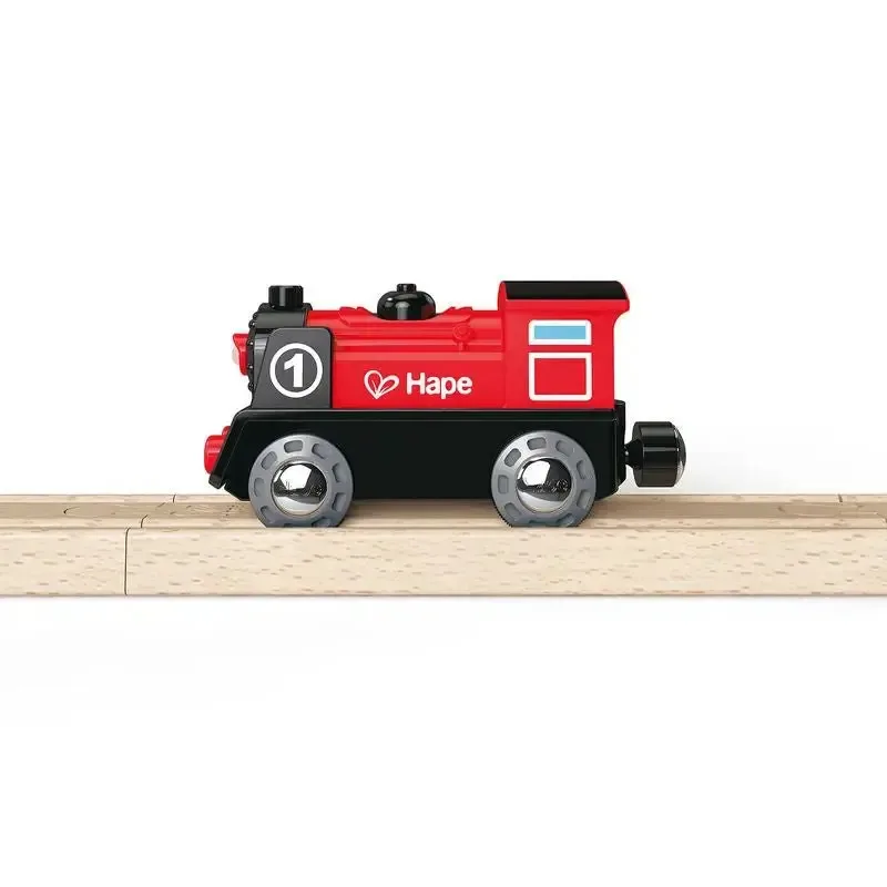 Red and black toy steam engine marked with the number 1 and the Hape logo, standing on a piece of wooden track.